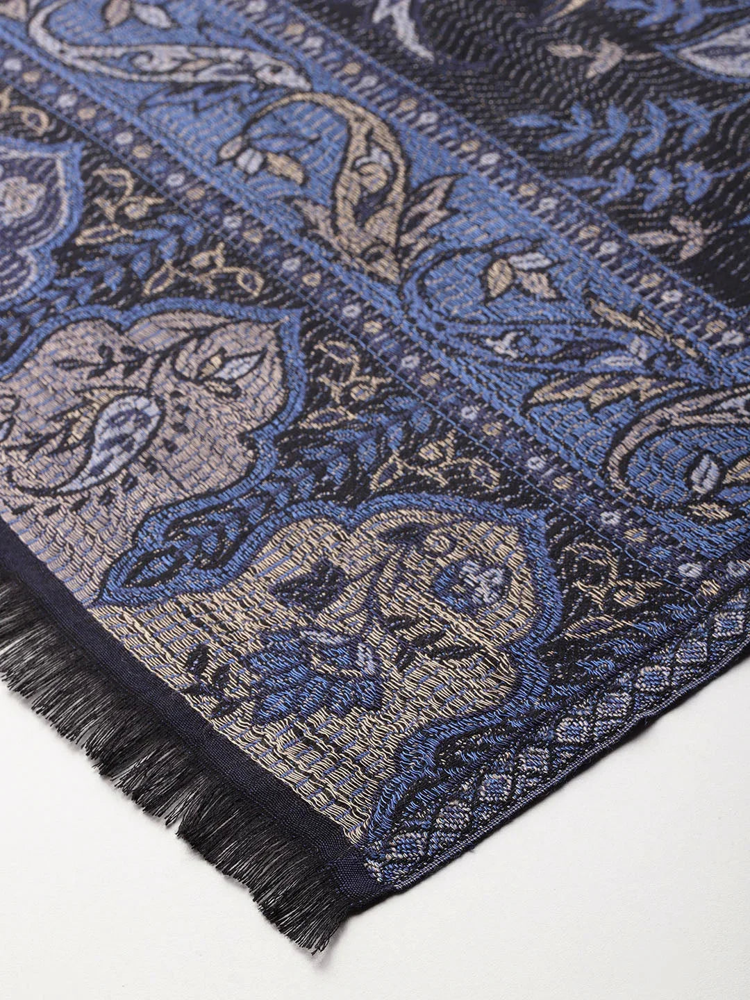 Close-up of a Kashmiri shawl with blue and beige floral embroidery and fringed edge