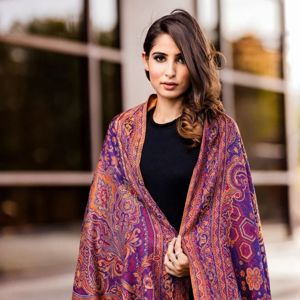 Woman outdoors wearing a Kashmiri shawl with vibrant floral embroidery and beige base