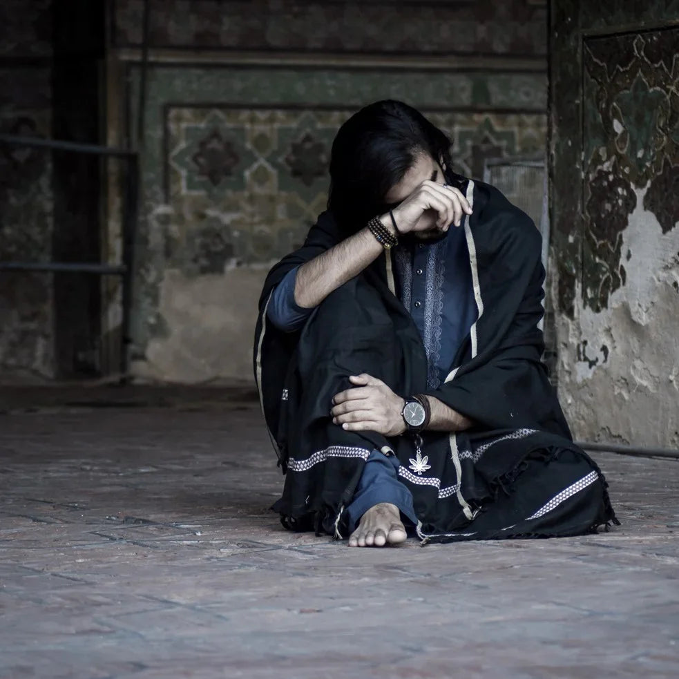 Woman outdoors wearing a Kashmiri shawl with vibrant floral embroidery and beige base