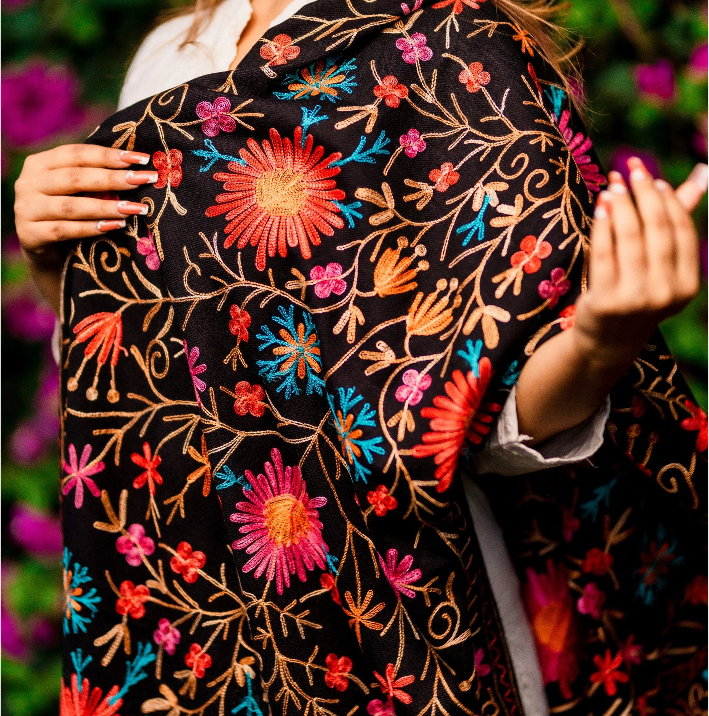 Woman outdoors wearing a Kashmiri shawl with vibrant floral embroidery and beige base