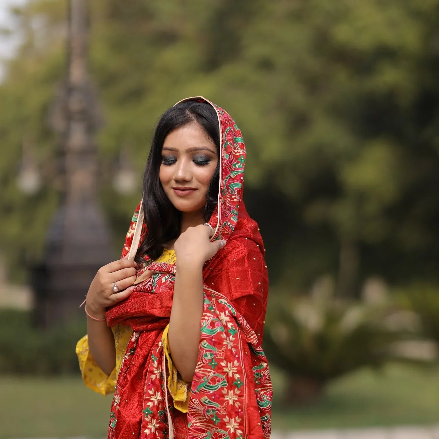 Woman outdoors wearing Kashmiri shawl with vibrant floral embroidery and beige base