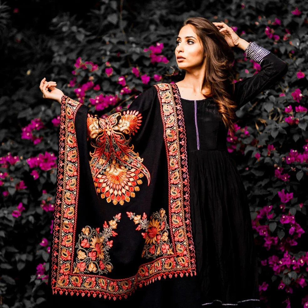 Woman outdoors wearing a Kashmiri shawl with vibrant floral embroidery and beige base