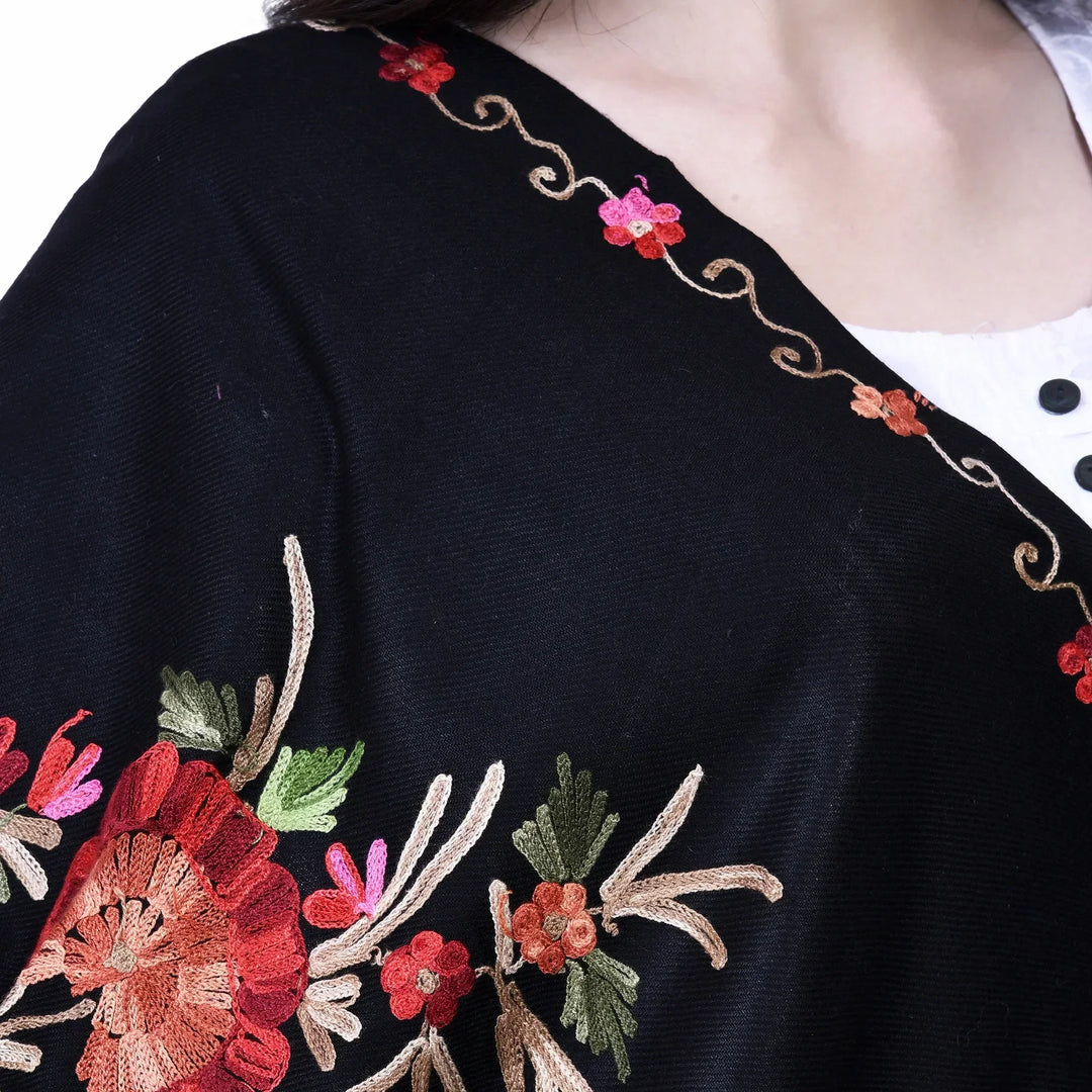 Woman outdoors wearing a Kashmiri shawl with vibrant floral embroidery and beige base
